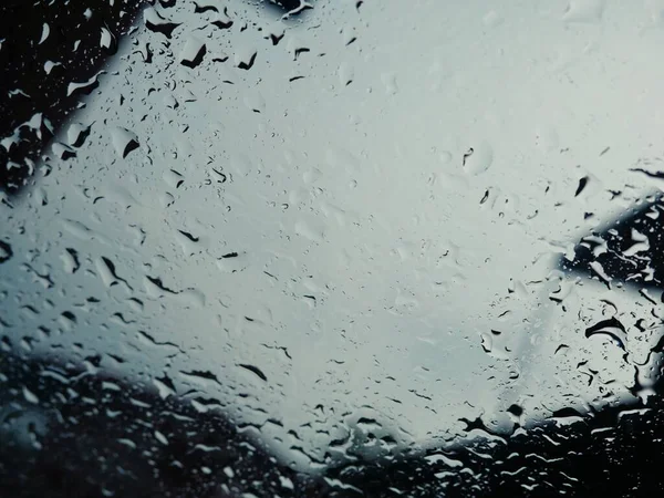 Rain drops on the car glass when it rains.