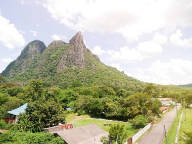 Gökyüzüne ve beyaz bulutlara bakan dik bir dağ uçurumu..