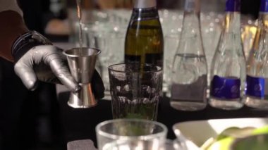 Barmen limonla kokteyli karıştırıyor. Partideki barmen içki dolduruyor.