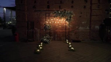 Tuğla duvarda çiçeklerle süslenmiş bir düğün için kemer.