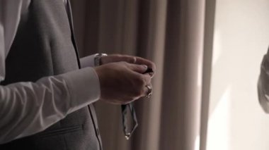 Genç bir adam siyah bir papyon tutuyor. Damat düğün ya da etkinlik için giyinir.