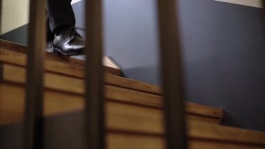 Takım elbiseli bir adam merdivenlerden iniyor.