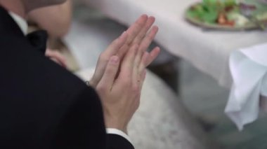 Partide restoranda masada oturan ve alkışlayan adam.