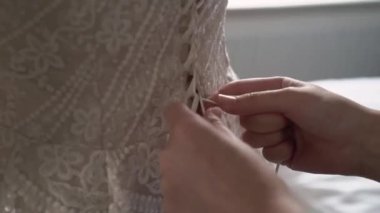 Nedime kravatları ve gelinin gelinliğini giymesine yardımcı olur. Sabah hazırlığı.