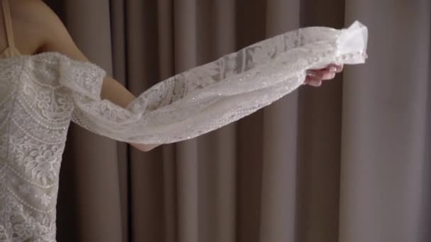 Braut hält Brautkleid in der Hand, Anzug für die Zeremonie, weiß — Stockvideo