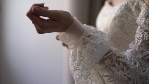 Sposa che indossa abito bianco da sposa, maniche abbottonate. Donna vestirsi — Video Stock