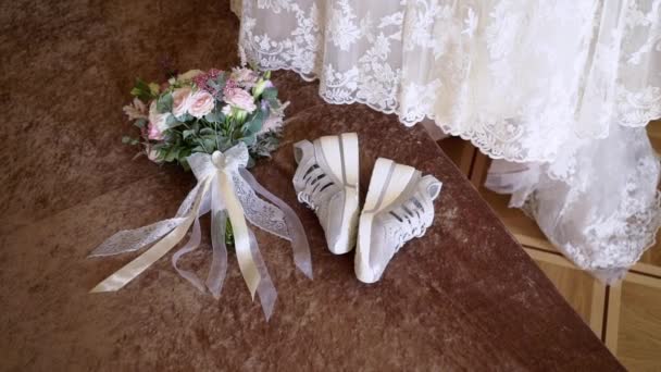 Esküvői ruha, menyasszonyi cipő tornacipő és csokor virágok — Stock videók