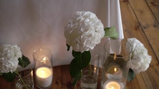 Bouquet di ortensie, fiori bianchi in vaso con candele decorate al matrimonio — Video Stock