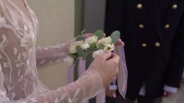 Gelin, nedimelere düğün töreni için çiçek bileziği veriyor..