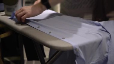 Genç çift ütüyle ütü yapıyor.