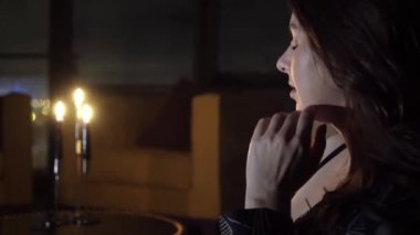 Genç seksi kadın gece yatak odasında mumlarla poz veriyor.