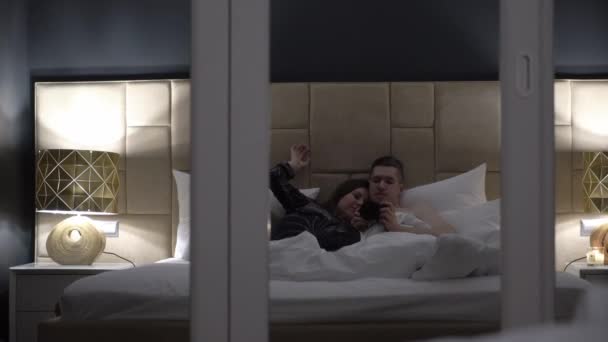 Ung sexet par omfavne i sengen om natten – Stock-video