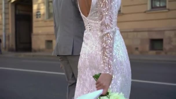 Bruid en bruidegom wandelen in een stad straat in de zomer dag Bruiloft — Stockvideo