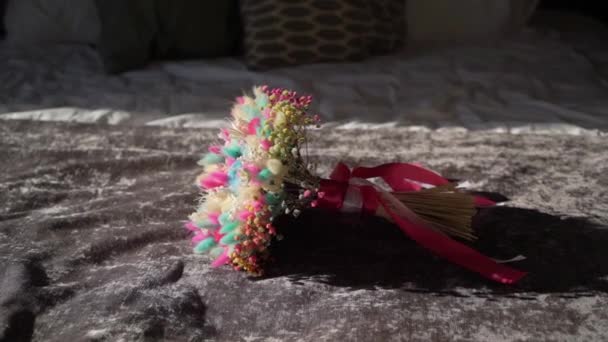 Mladá žena ráno bere svatební kytici květin s růžovými červenými stuhami. Nevěsta — Stock video