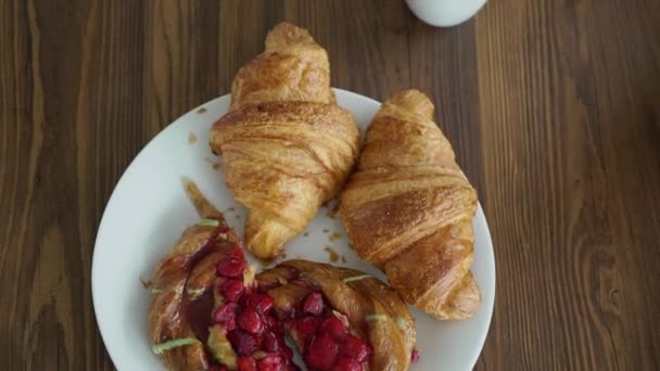 Pár brát a jíst croissanty k snídani — Stock video