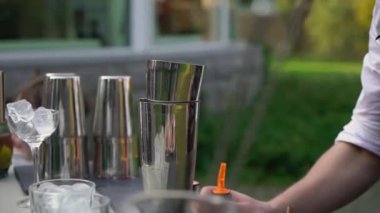 Barmen barda kokteyl yapar. Partide alkollü içecekler doldurur.