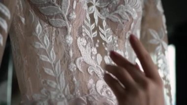 Gelin gelinliğine dokunuyor. Gelinlik