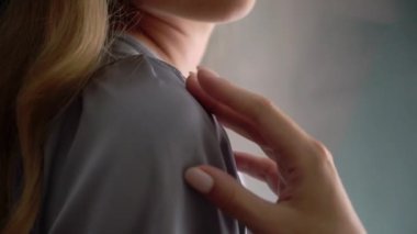 Gri ipek bornoz giymiş genç bir kadın.