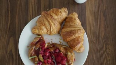 Çiftler kahvaltıda kruvasan yiyor.