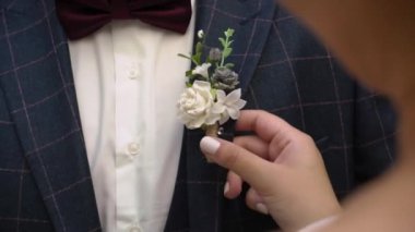 Gelin, damat için düğün günü yaka çiçeği taktı..