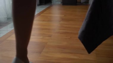 Genç bir kadın yatak odasına topuklu ayakkabılar ve bornoz iç çamaşırlarıyla giriyor. Gelinin düğün sabahı.