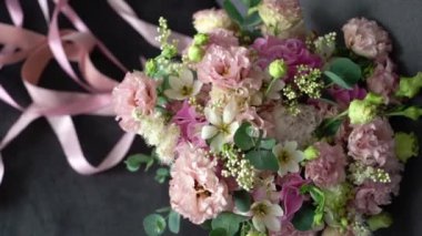 Pembe mor güller ve şakayık çiçeklerinden oluşan bir düğün buketi. Gelin aksesuarları.