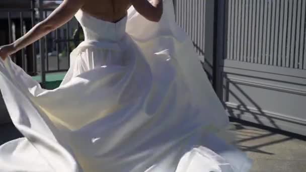Promenade de la mariée et tourner autour dans une rue de la ville en été. Couple de mariage amoureux