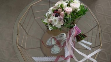 Gelinlik buketi beyaz ve pembe güller. Gelin aksesuarları Ayakkabılar ve yüzükler.