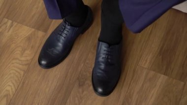 Genç adam siyah ayakkabıları giydi. Damat düğün ya da etkinlik için giyinir.