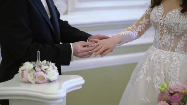 The groom puts a ring on the brides finger at the wedding ceremony. Exchange of rings — Stock Video