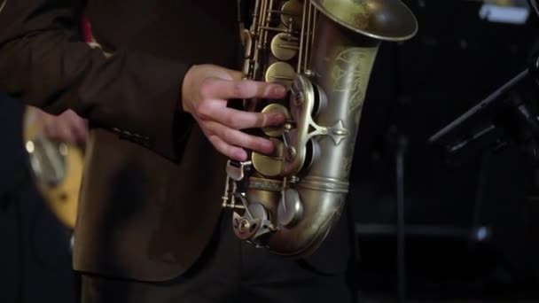 Saxophonist playing saxophone at stage. Sax musician player with band at concert — Stock Video