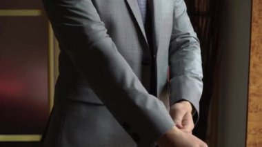 Genç bir adam smokin ceketini ilikliyor. Damat düğün ya da etkinlik için giyinir..