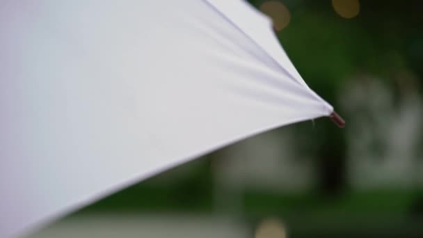 Біла парасолька в дощову погоду — стокове відео