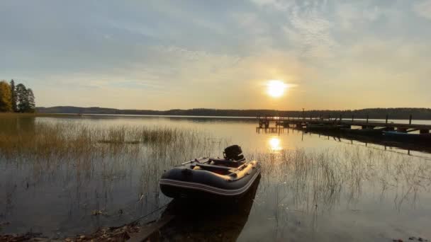 Schlauchboot zum Angeln am See in der Nähe der Seebrücke bei Sonnenuntergang — Stockvideo