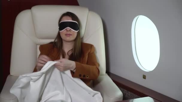 Woman sleeping in airplane, business first class. Luxury travel journey in private jet. Girl relaxing in mask — Vídeos de Stock