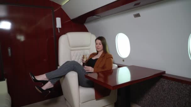 Woman passenger in airplane business first class with champagne. Luxury girl in private jet flight travel — Vídeos de Stock