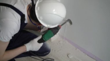 İnşaat alanında çalışan bir işçi yumrukla bir apartman dairesini ya da evi tamir eder.