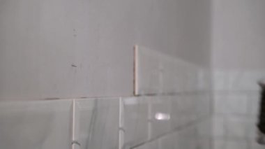 İnşaat alanında çalışan bir inşaatçı yenileme onarımı yapıyor. Duvara fayans seriyorum.