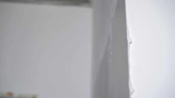 A construction worker builder makes repairs renovation in an apartment or building. Put on a putty, leveling the walls — Stock Video