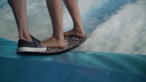 Девушка-сёрфер катается на доске для серфинга на искусственной волне в волновой машине. — стоковое видео