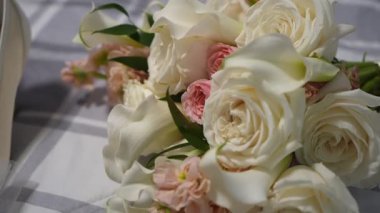 Yakın plan Beyaz Gül Düğün Buketi, Çiçekçi Narin Zambakları Düzenleyen Pastel Sprey Güller Damalı ketenler, Yumuşak Doğal Açık Renkli,