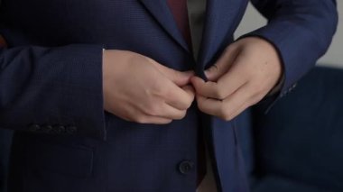 Resmi takım elbiseli bir adamın kravatını düzeltmesi, donanma ceketi giymiş bir adamın kravatını düzeltirken yakın görüntüsü.