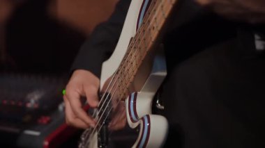 Fingers Plucking White Electric Bass Closeup Fretboard Amp Mixing Console Background Solid Pocket Groove Focused Studio Take