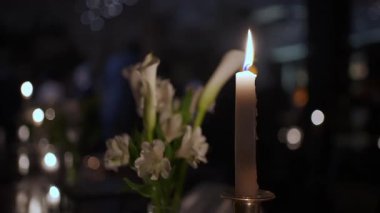 Loş Restoranda Uzun Mum ve Lily Buket Parıltısı Yumuşak Bokeh Işıkları Sinema Arkaplanı, Zarif Masa Masası Özel Masa Dekoru