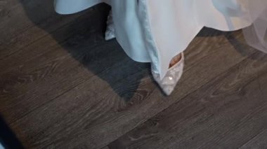 Gelin Ayakkabısı Elbisenin Altında Bakıyor, Dantelli Pompalı Ahşet Zeminde, Saten Parmak ve Hassas Nakış Görünürde, Pencereden Yumuşak Gölge, Sessiz