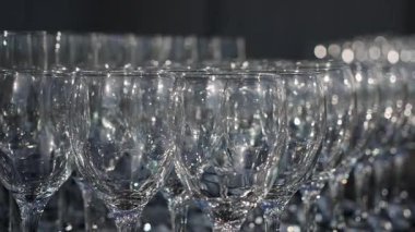 Sıralar halinde dizilmiş kristal şarap kadehleri, Işıl ışıl ışık altında parıldayan parlak Bokeh yansımaları,