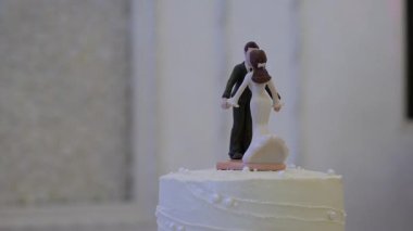 Gelin ve damat figürleri Kekin Üzerinde Öpücük, Yumuşak Bokeh Çiçeği Arkaplanı, Fildişi Buzlanma, Zarif Karşılama Işıklandırma, Kapanış Minyatür Üzerine Odaklanma