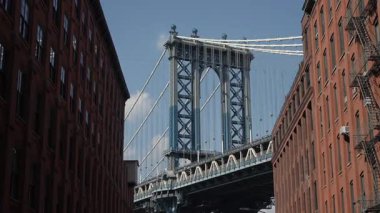 Manhattan Köprüsü Redbrick binaları, kablolar ve mavi gökyüzü dar kaldırım kaldırımları tarafından çerçevelendi.