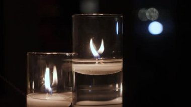 Yüzen Mumlarla İki Cam Vokal, Temiz Su Üzerinde Dans Eden Sıcak Kehribar, Arkaplanda Yumuşak Bokeh Işıkları, Yansıtıcı Cam