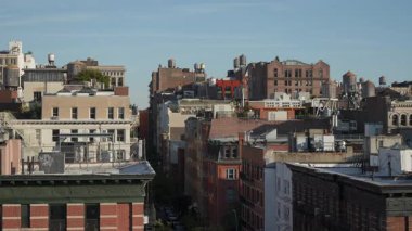 Yoğun Şehir Blokları 'nın Çatı Panoraması, Düşük Yükselen Binalar ve Açık Mavi Gökyüzü Altındaki Su Kuleleri, Bacalar ve Noktalı Antenler,